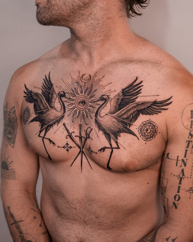 Graphic chest tattoo featuring two cranes, sacred geometry and an eye by Azone Tattoo Studio in Hanoi and Saigon