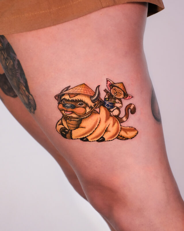 Color tattoo of a buffalo and cat wearing Vietnamese conical hats