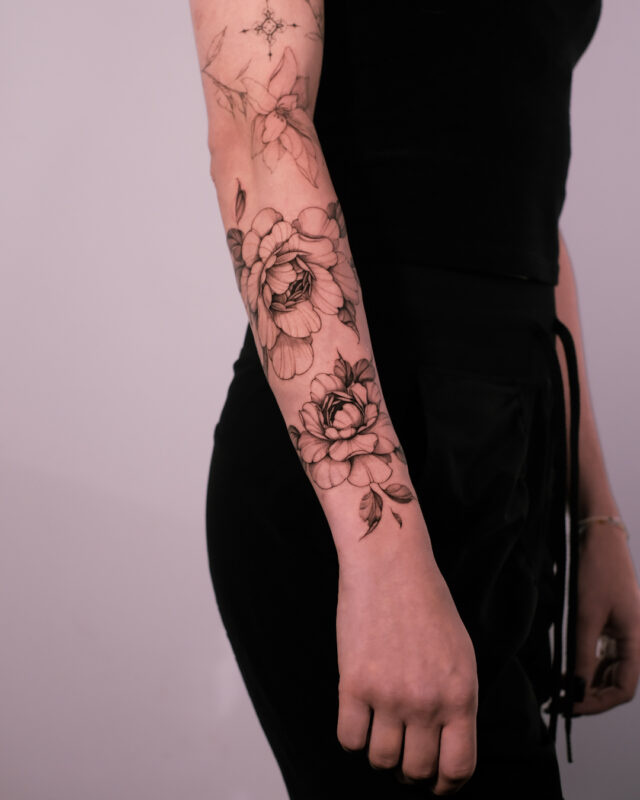Fine line peony flower tattoo on the forearm by Azone Tattoo Studio in Hanoi
